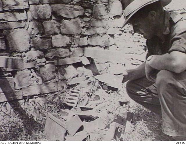 1146257052_121435-MAPEPORTUGUESETIMOR1945-12-12.SERGEANTG.MILSOMFORMERLYOF22NDINDEPENDENTCOMPANYANDN-FIELDTEAMATTACHEDTOTIMFORCEEXAMINESTHEREMAINSOFBATTERIES....jpg.00a648637b39c2c553d78f7a9b7fdc4b.jpg
