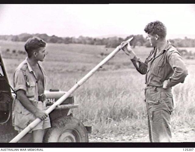 1558337411_125207-LAUTEMPLAINPORTUGUESETIMOR.1946-01-04.LIEUTENANTBUSHOFFICIALARTISTANDSERGEANTMILSO-RYHISTORYFIELDTEAMEXAMININGONEOFTHESHARPENEDBAMBOOSTAKES....jpg.40a08c258f463a8f7baff88424e327b0.jpg